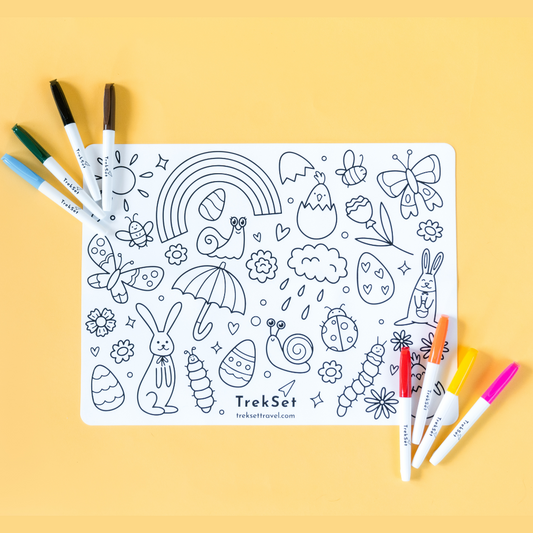 A reusable silicone coloring mat with a springtime Easter design, accompanied by eight dry erase markers, displayed on a yellow background.