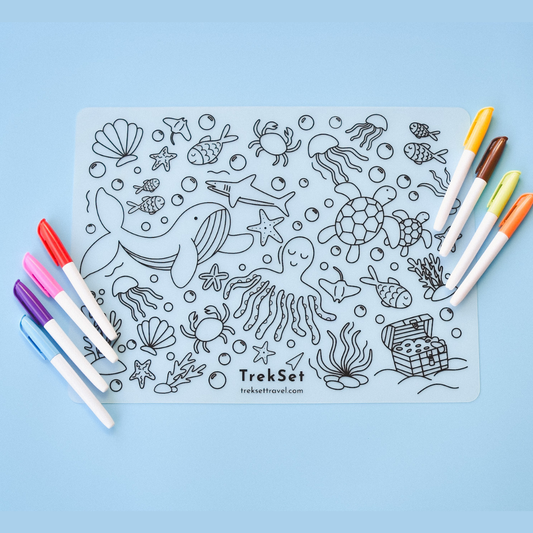 Coloring sheet with ocean-themed illustrations and markers on a blue background